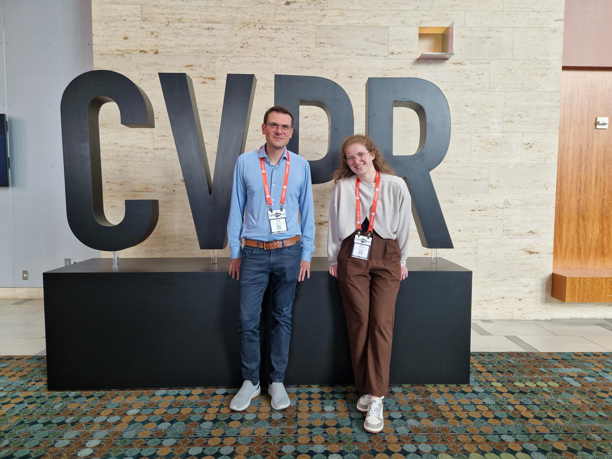 David and Anna in front of the conference logo.